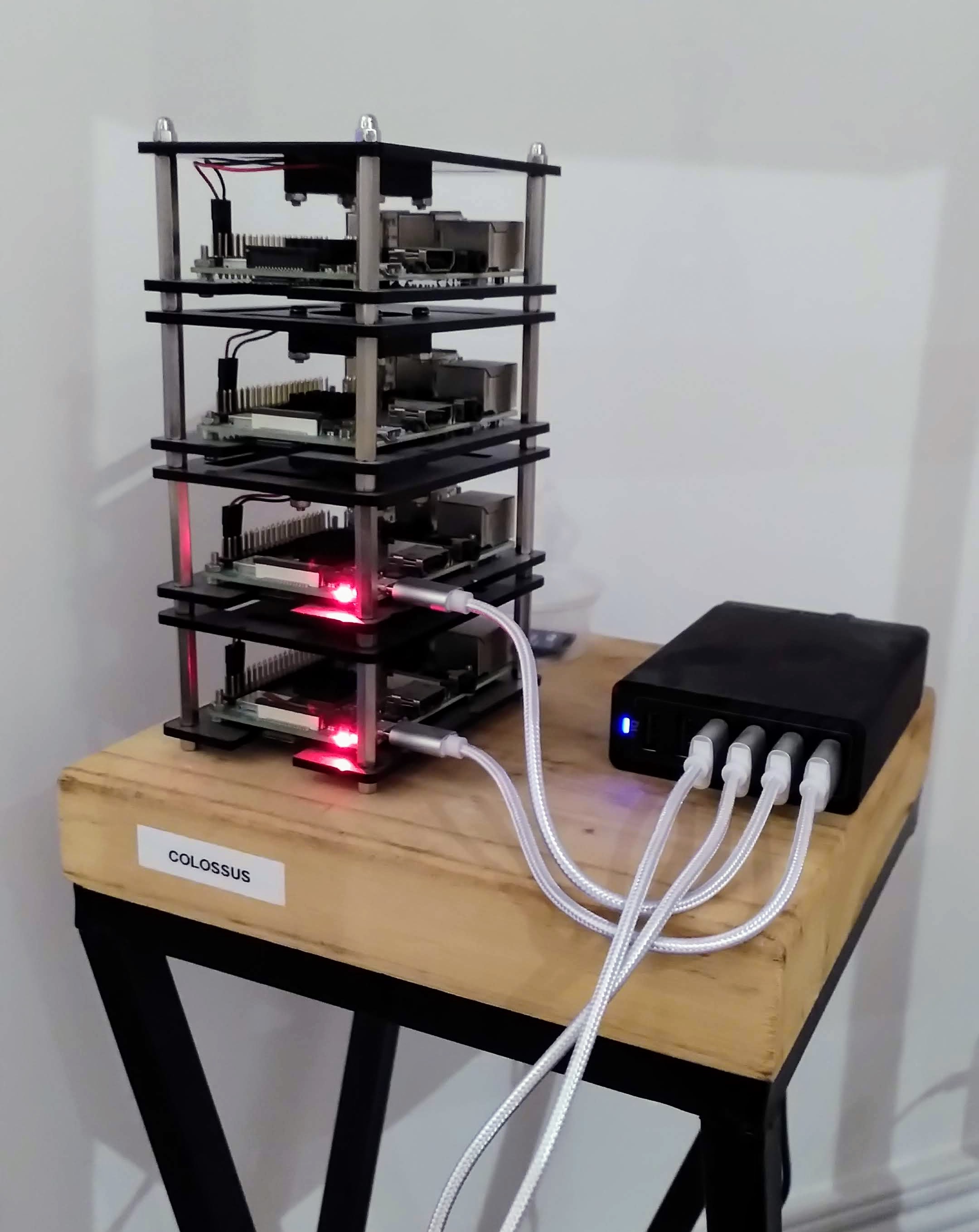 Colossus, a tiny stack of 4 Raspberry Pi computers. 2 of them have little red lights on to indicate that they are powered.